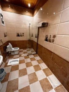 Al Fayşalīyahشقق الروشن الجوفي的一间带卫生间的浴室和瓷砖地板。
