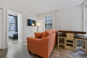 纽约Inspiring Urban Life, Times square Apartments的客厅配有橙色椅子和书桌