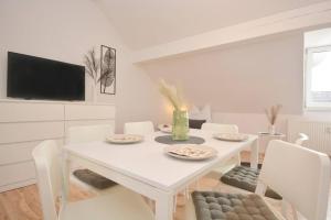 罗特RT01-RI Apartment in Roth的白色的用餐室配有白色的桌椅