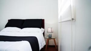 昆卡Casa Roja Residencia 10-51的一间卧室配有一张床和一张带台灯的桌子