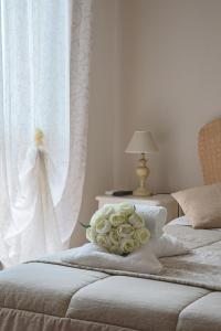 菲乌米奇诺Giramondo Guest house的两张床,配有白色窗帘和一束玫瑰花
