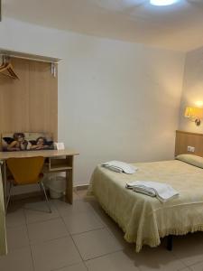 塔拉戈纳塔拉戈纳阿罕布拉旅馆的客房设有床、书桌、桌子和床筒。