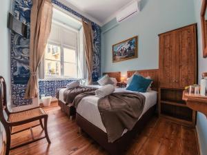 里斯本卡辛纳弗洛雷斯旅馆的蓝色墙壁客房的两张床