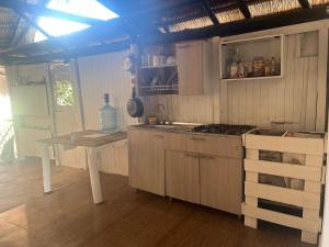 卡塔赫纳Punta Arena EcoHostal and EcoFit – Your Eco-Friendly Oasis 02的厨房配有桌子和炉灶。 顶部烤箱