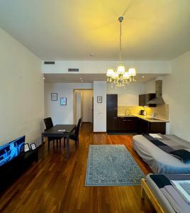 布达佩斯NOVO Central Apartments的一间卧室配有一张床铺和一张桌子,还设有一间厨房