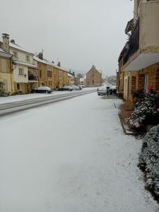 Thélonne"Chez la Joe"的一座有建筑物的小镇上一条有雪覆盖的街道