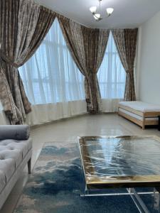 阿吉曼F22,R2 Sea&city view room in three bedroom apartment, separate bath outside的客厅配有沙发和桌子