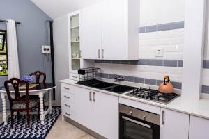 波罗瓜尼Seloko Guest Cottage的厨房配有白色橱柜、水槽和桌子