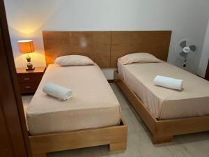圣菲利佩Nerys House的卧室内的两张床,配有灯和床头柜
