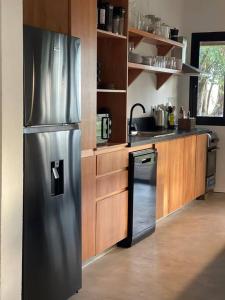 何塞伊格纳西奥CASA NEGRA Jose Ignacio的厨房配有不锈钢冰箱和洗碗机