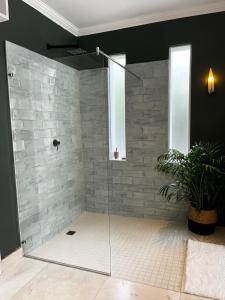 赫曼努斯Westcliff Cottage-NO Power outages- 1,5km form central Hermanus的浴室里设有玻璃门淋浴