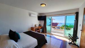 马萨特兰Hill House Mazatlan - Bed & Breakfast的一间卧室配有一张床,享有海景