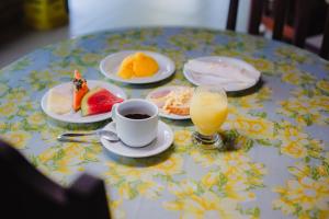巴雷里尼亚斯Portal do Sol Lençóis Pousada的餐桌,盘子上放着食物,还有一杯橙汁