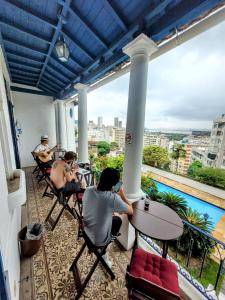 里约热内卢Rio World Connection Hostel的一群人坐在阳台上的桌子上