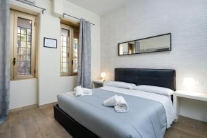 罗马Comfort Rooms Piazza Mariano Armellini的卧室配有一张床,墙上设有镜子