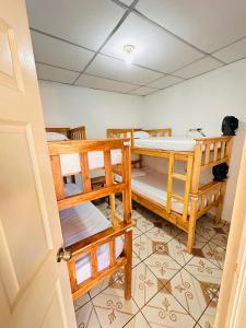 圣安娜Hostal Villa Marta的带三张双层床和一扇门的房间