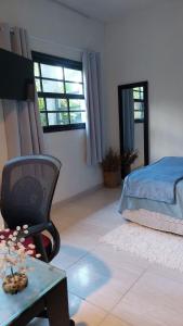 里约热内卢Lofts da Monica的一间卧室配有一张床、一把椅子和一张桌子