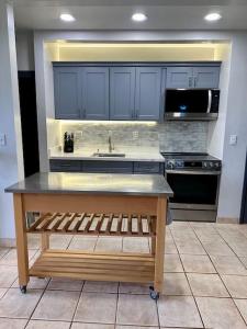 蒙内罗亚Kepuhi Sunset Ocean View - Ground Floor Unit by Wrinkly Sheets, LLC的厨房配有蓝色橱柜、水槽和炉灶。