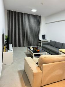 沙迦Al jada apartment Sharjah的客厅配有沙发和桌子