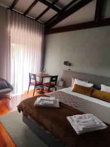 RendufeQuinta do Esquilo - Hotel Rural的一间卧室配有一张床和一张桌子及椅子