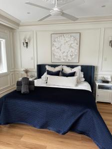 悉尼Tusan Villa Little Manly的一间卧室配有一张带蓝色毯子的大床