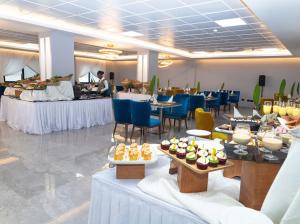阿克拉机场东橡树广场酒店的餐厅设有桌椅和餐桌上的甜点