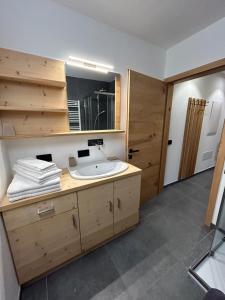 迪马罗Dolomia Apartments & Spa的一间带水槽和镜子的浴室
