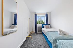 沃特福德Spacious 2 bedroom flat by Zen Abodes Short Lets & Serviced Accommodation with Free Parking & Free Wifi的一间卧室配有两张床和镜子