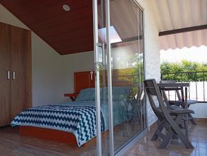San MiguelHospedaje Rural La Fortaleza的一间卧室设有一张床和玻璃墙