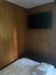 科伊艾科Silencioso y a pasos del centro的一间卧室配有一张床,墙上配有电视