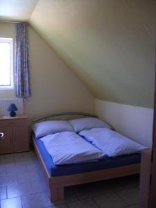 赫维兹Ferienhaus Hartmann的一间卧室配有一张带蓝色床单的床和一扇窗户。