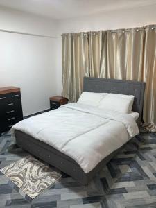 特马Lovely 1-bedroom Unit的卧室内的一张带白色床单和枕头的床