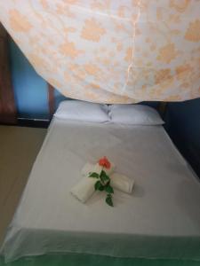 ArusíPerla del cabo的一张带两条毛巾的床,上面有花