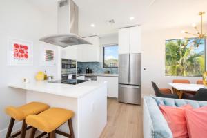 North SideSilver Reef 2 Oceanfront Condo的厨房以及带白色橱柜和桌椅的客厅。