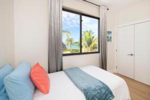 North SideSilver Reef 2 Oceanfront Condo的一间卧室设有床铺和种有棕榈树的窗户。