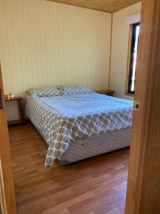 库拉考廷Cabañas Captren Andino的一间卧室配有一张带蓝色棉被的床
