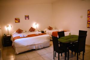门多萨Umbral del Aconcagua的酒店客房带两张床和一张桌子以及椅子。