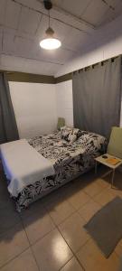 维拉卡洛斯帕兹Habitación En La Casita de Marley的一间卧室配有一张床和两把椅子