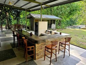 Kampong RugardingRugading Riverside Villa near Kota Kinabalu.的一个带酒吧和椅子的户外厨房