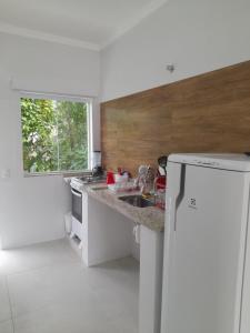 乌巴图巴Moriá Flats的白色的厨房设有水槽和窗户