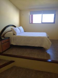 Balneario IporaLa Casona del Lago的一间卧室设有一张大床和窗户