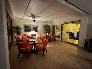 普拉亚科罗纳多GOLF CORONADO LUXURY MANGO SUITE PRIVATE POOL FEE INCLUDED的一间餐厅,房间内设有橙色椅子和桌子