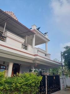 蒂鲁奇奇拉帕利Shri Sai Baba Homestay - EB Colony - Trichy的白色的房子,有黑色的大门