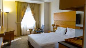 埃尔比勒Hotel Hilen De Ville的酒店客房设有床和窗户。