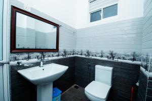 纳拉坦尼亚Adams Peak Inn的一间带水槽和卫生间的浴室以及窗户。