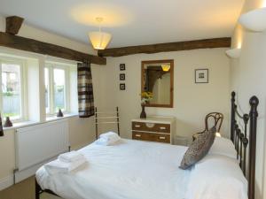 Aldringham3 Hazlewood的卧室配有一张白色大床和镜子