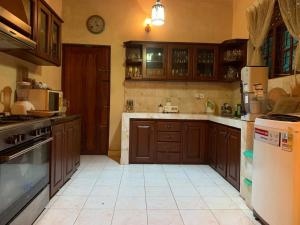 康提Dili's Home Stay的一个带木制橱柜和冰箱的大厨房