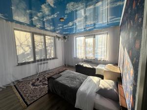 阿拉木图Quiet place的客房设有三张床和蓝色天花板。