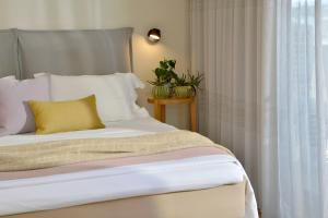 雅典Mirivili Rooms & Suites的窗边的一张带黄色枕头的床