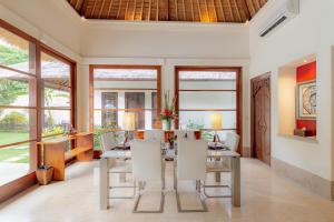 金巴兰Villa Dorado - Steps from Jimbaran Beach的一间带桌椅的用餐室